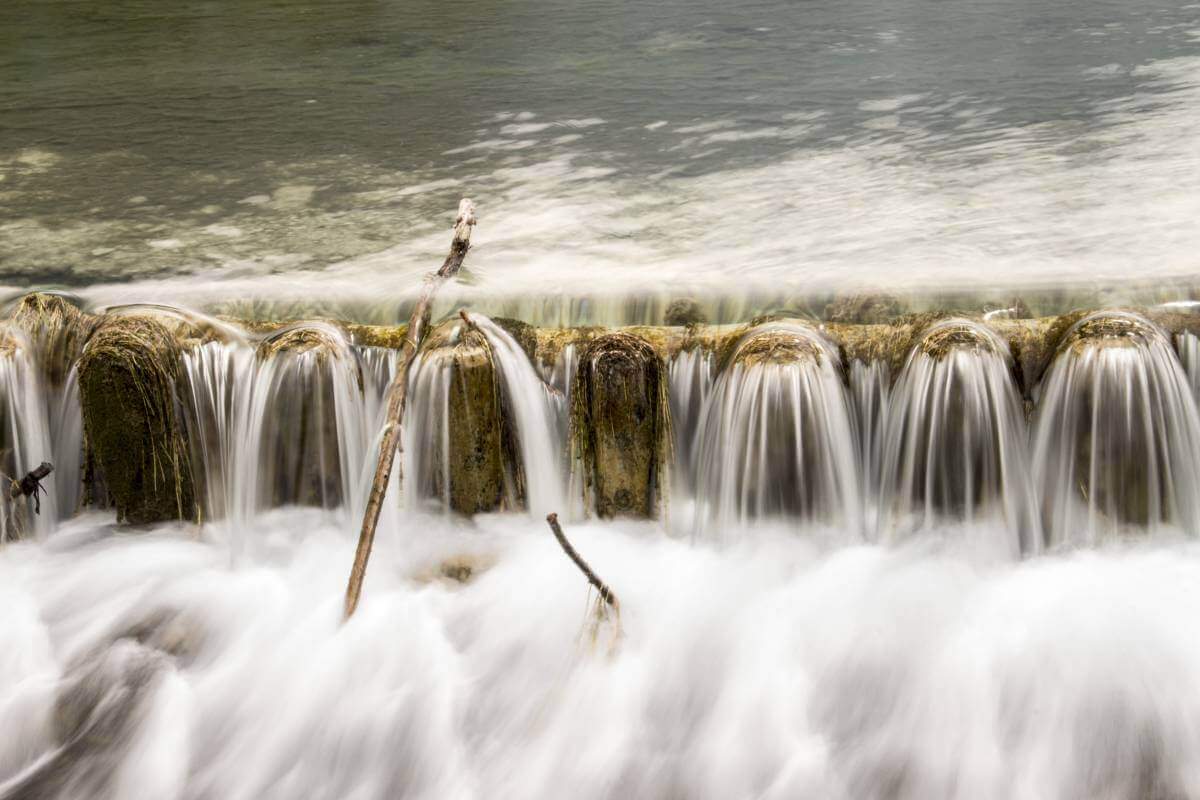 Ein Wehr wird von Wasser überströmt – weiches Wasser lässt das Foto malerisch wirken – Quelle: René Gropp