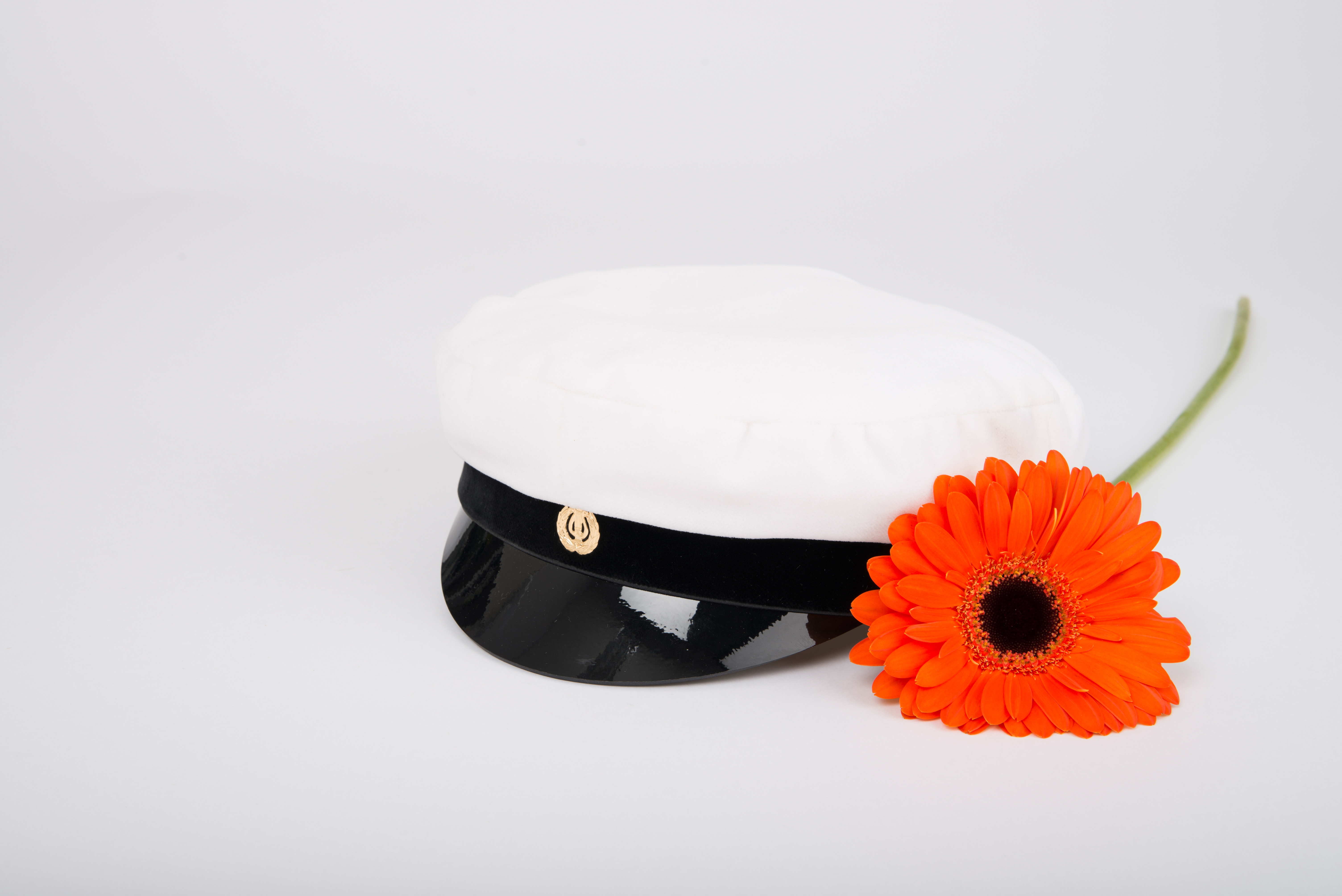Ylioppilaslakki ja oranssi gerbera