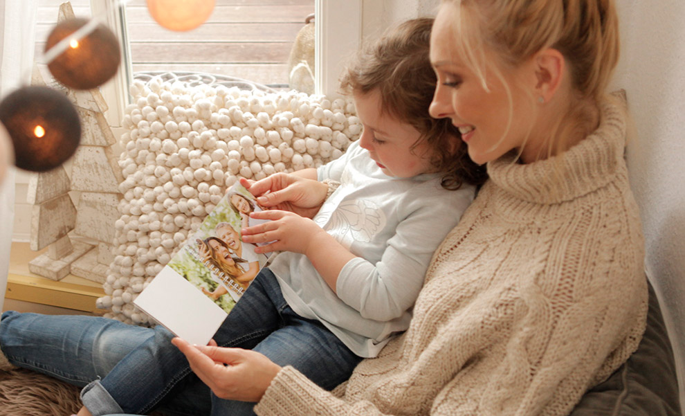 Mamma och dotter läser en fotobok Fotoböcker är mer tillgängliga.