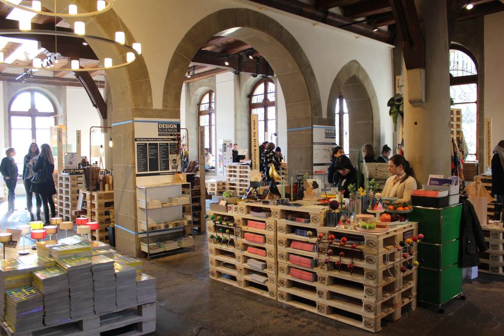 Marktbesucher schauen sich ausgestellte Produkte in der Halle an