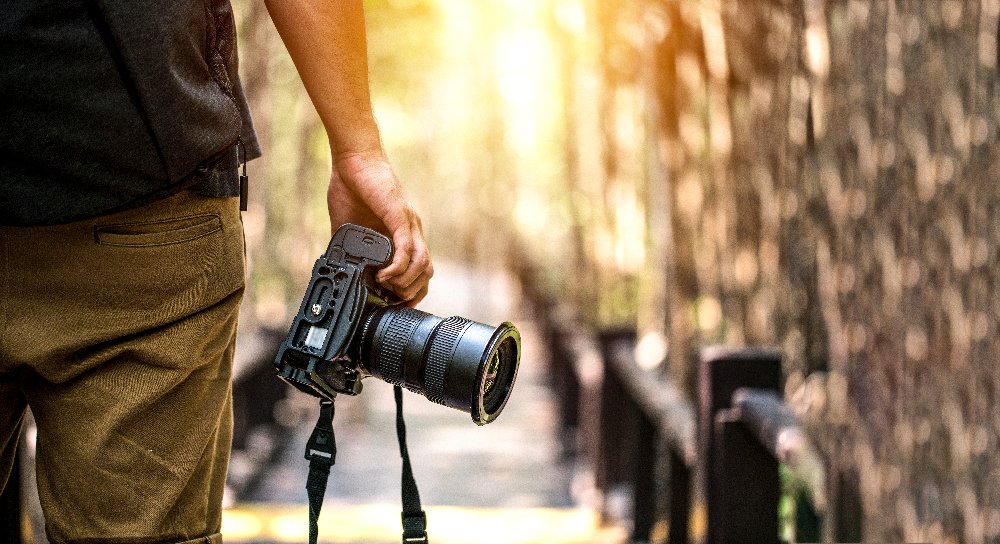 Fotografie Glossar – Mann hält Kamera in der Hand