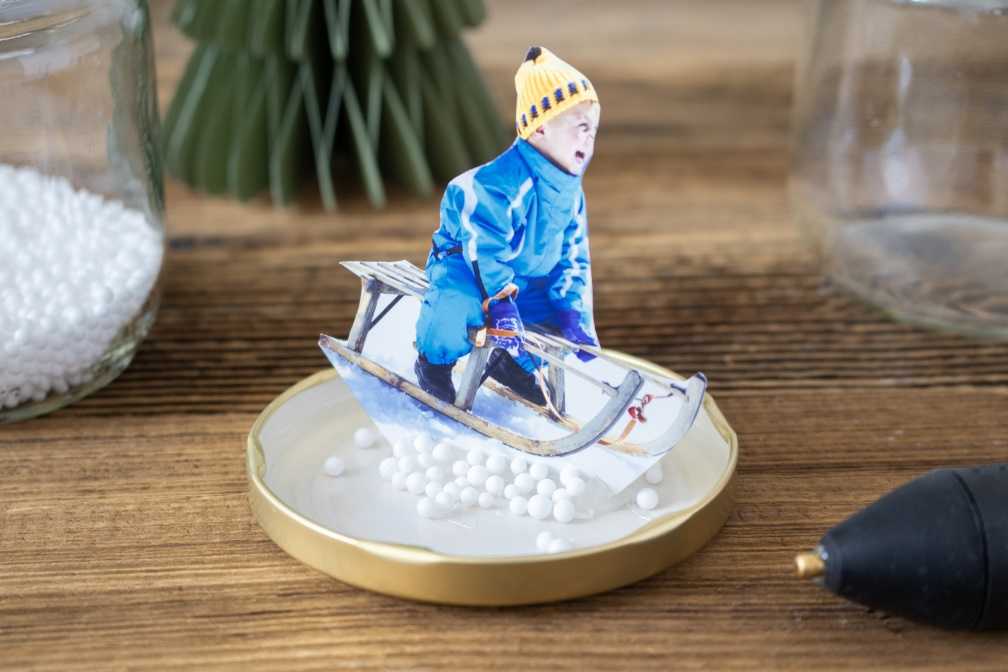 Zwischenschritt des Fixierens zum Basteln einer Schneekugel Zwischenschritt des Fixierens zum Basteln einer Schneekugel