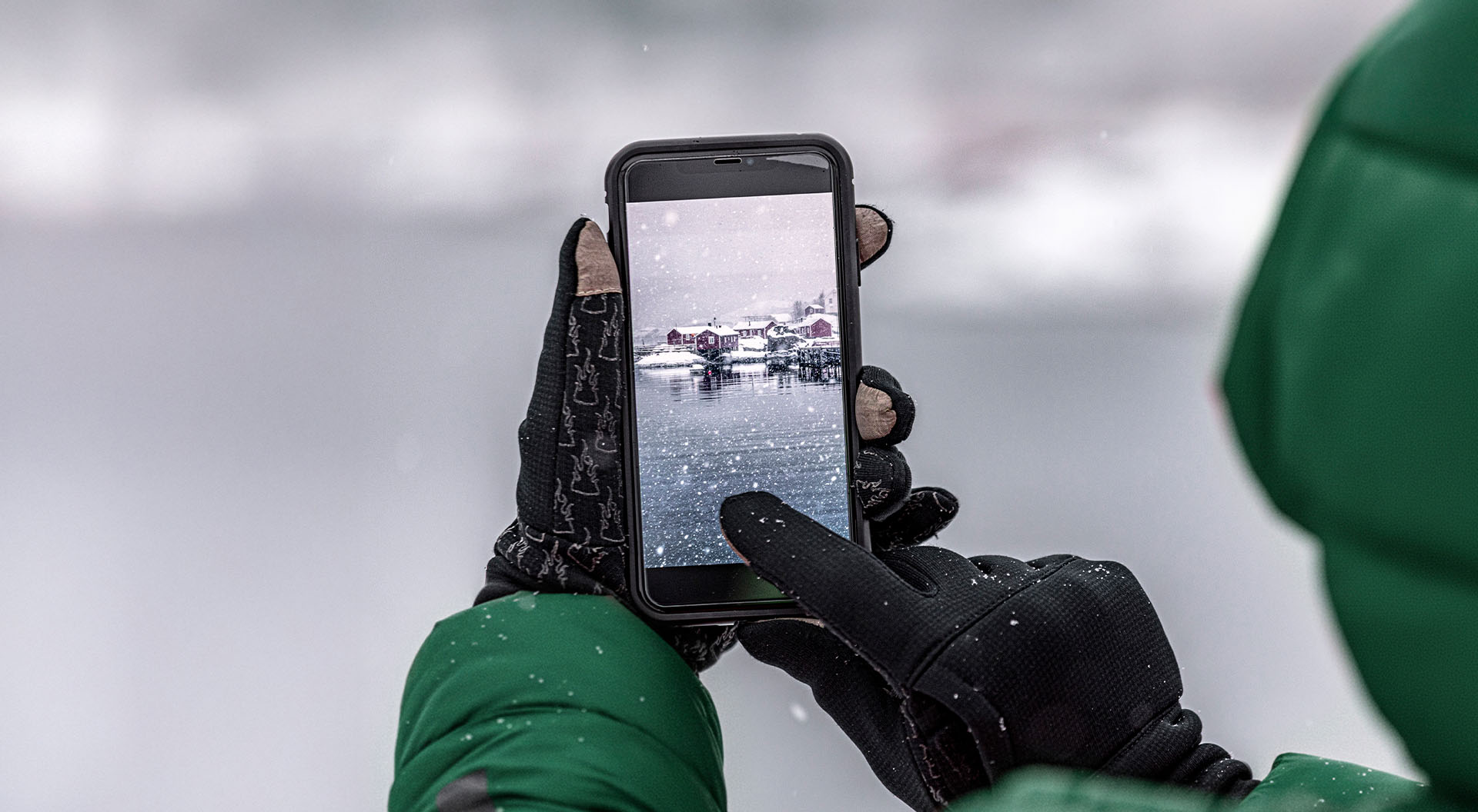 En person som tar ett foto av ett vintervatten med en telefon