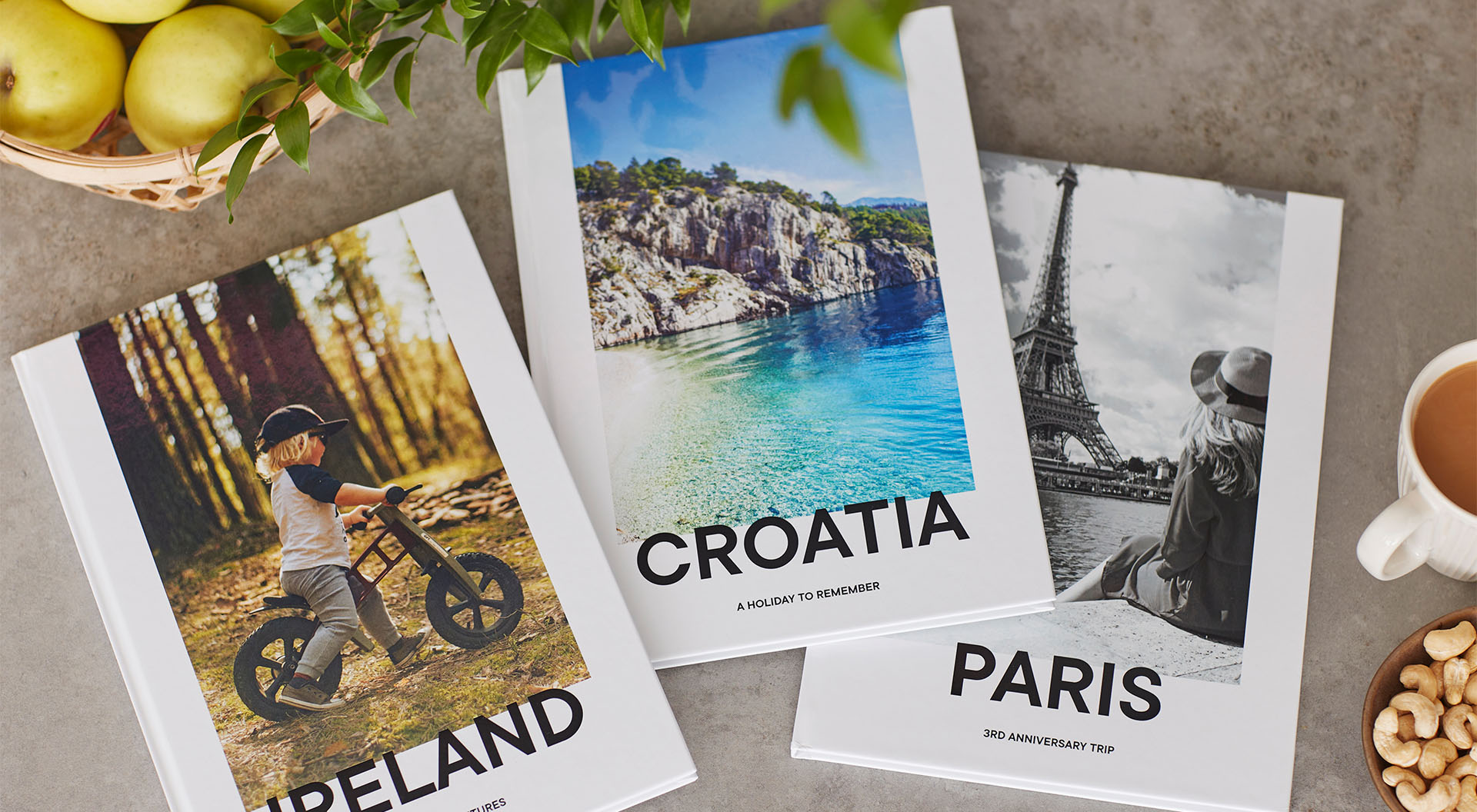 3 travel photo books pictured on a table