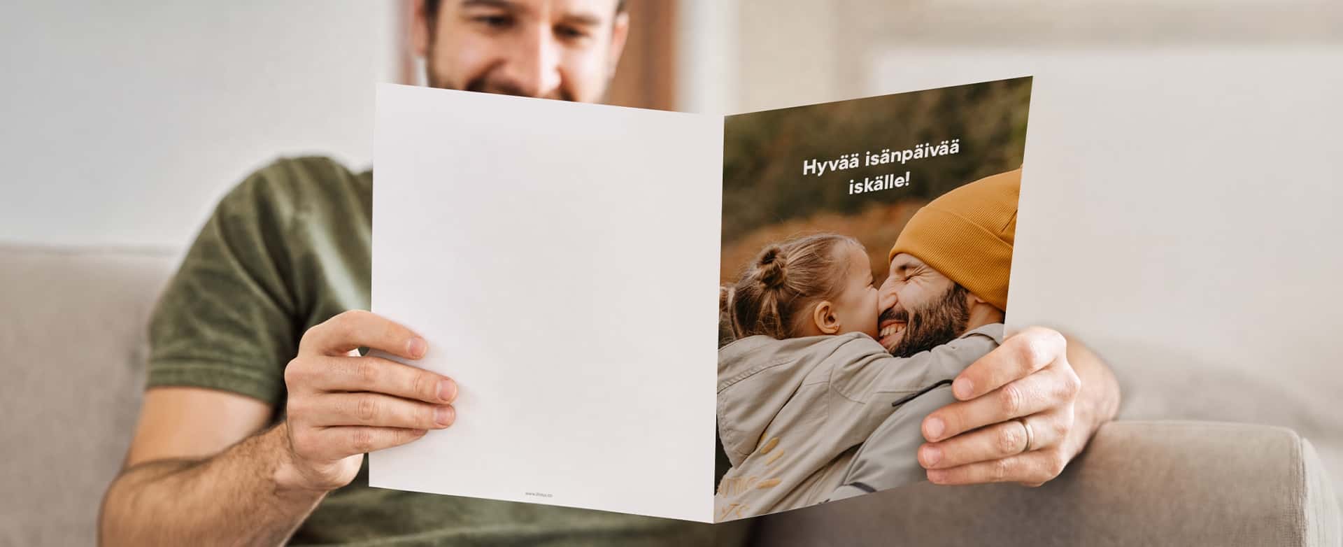Isä katselee jättikokoista isänpäiväkorttia