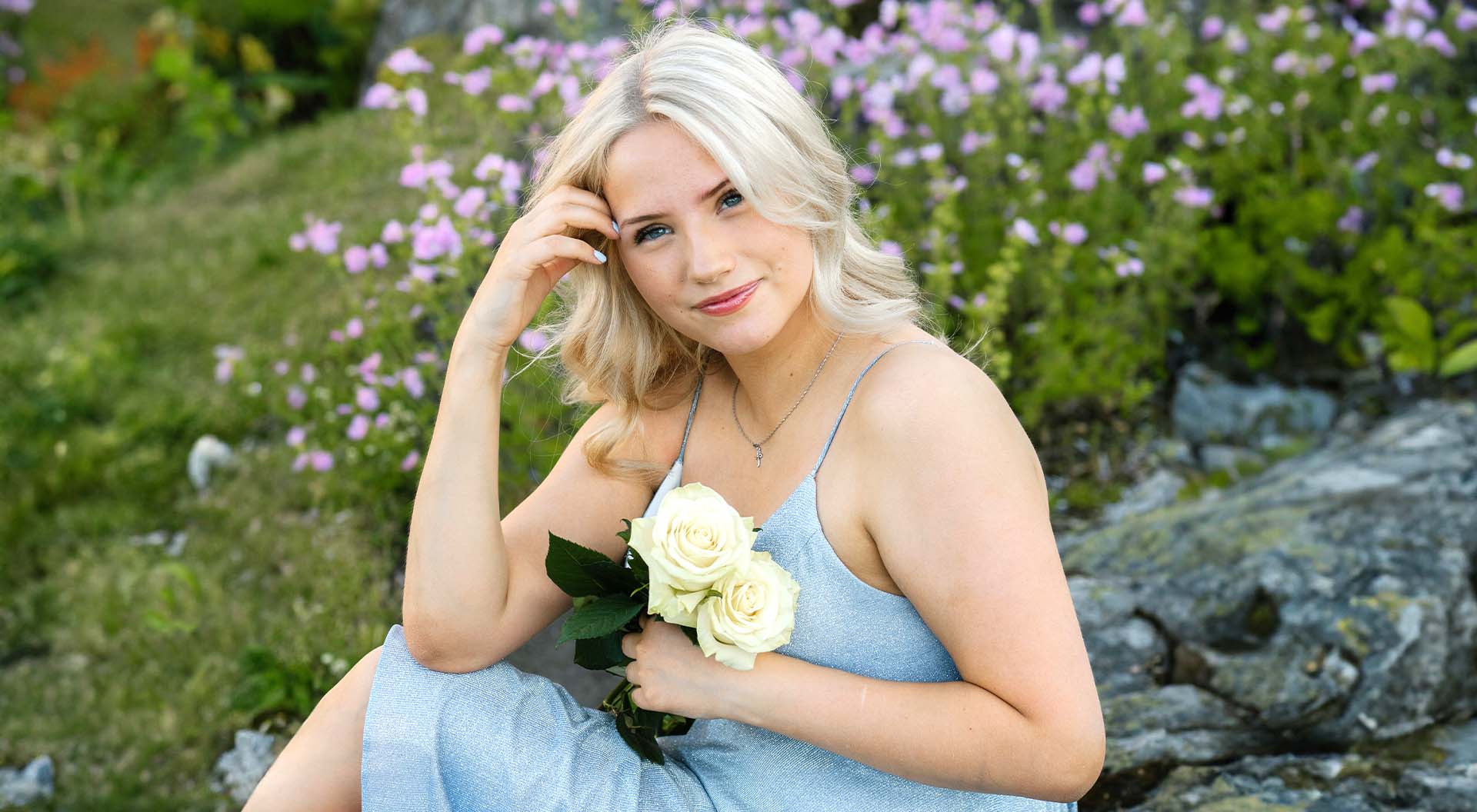 Young woman posing with white roses outdoors