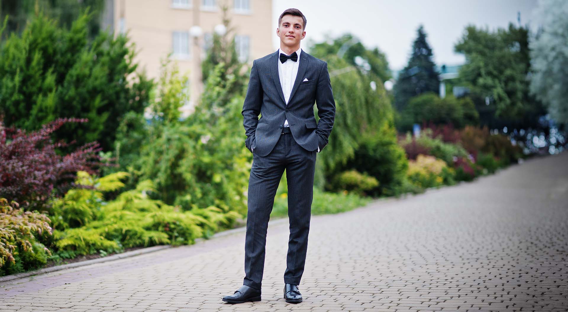 En ung man fotograferad utomhus i kostym