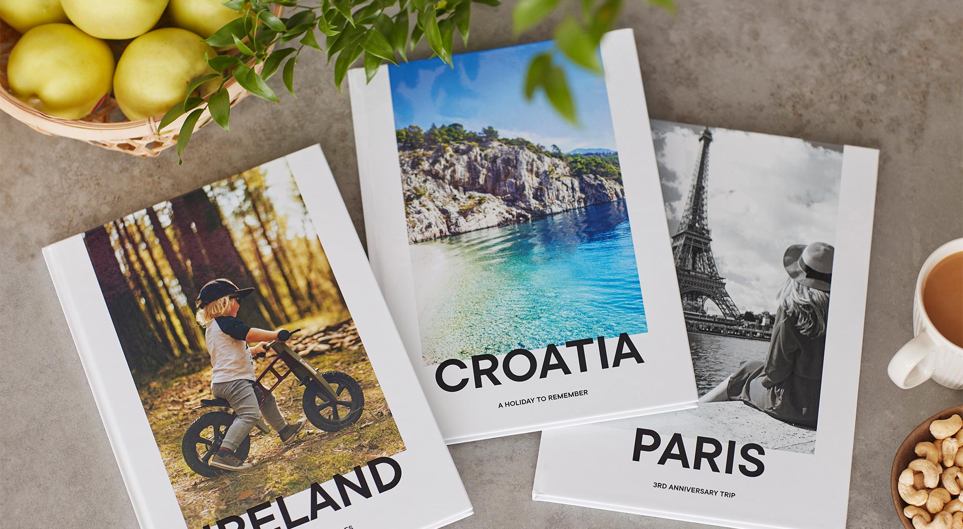 3 travel photo books pictured on a table